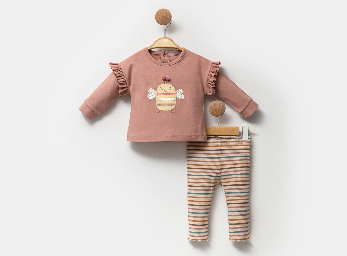 Ensemble bébé avec t-shirt rose poudré et pantalon rayé multicolore.