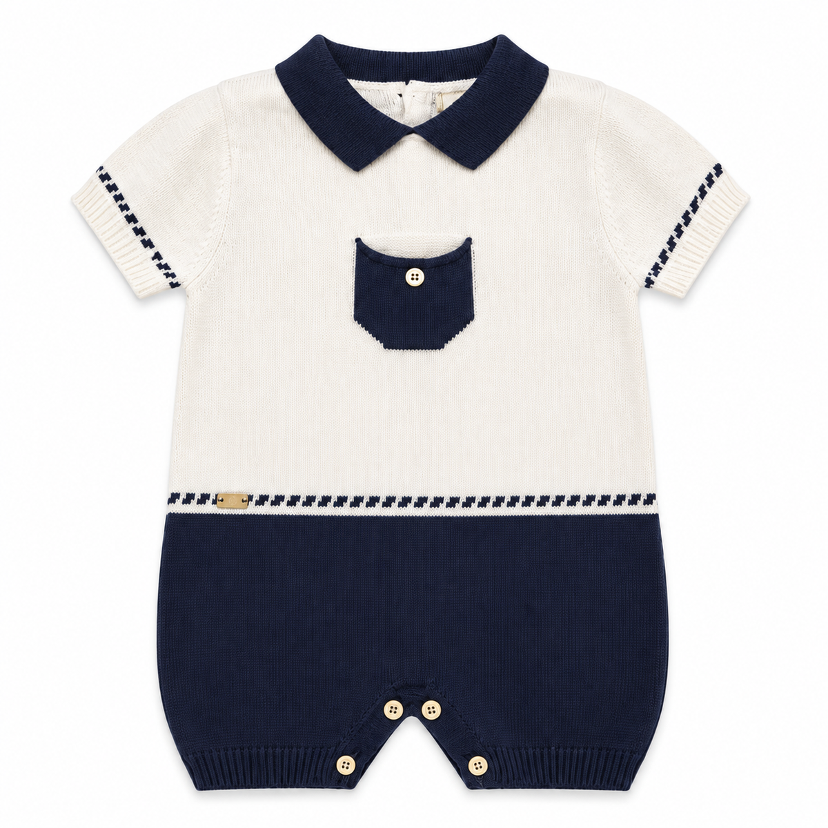 Combinaison bébé en tricot blanc cassé et bleu marine, col contrasté, poche, boutons.