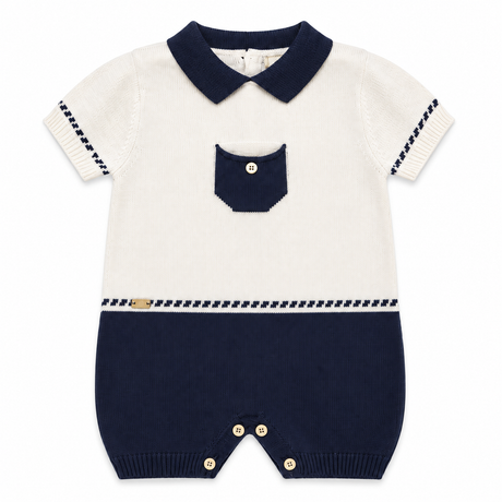 Combinaison bébé en tricot blanc cassé et bleu marine, col contrasté, poche, boutons.