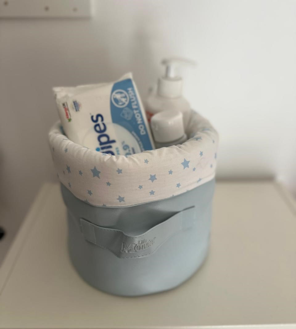 Panier rond gris clair avec bord en tissu blanc à étoiles bleues