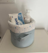 Panier rond gris clair avec bord en tissu blanc à étoiles bleues