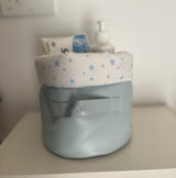 Panier rond gris clair avec étiquette en cuir et doublure blanche à étoiles bleues