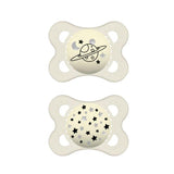 Deux sucettes MAM en silicone ivoire, motif planète et étoiles.