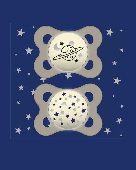 Deux sucettes MAM ivoire avec motifs planète et étoiles, anneaux ajourés.